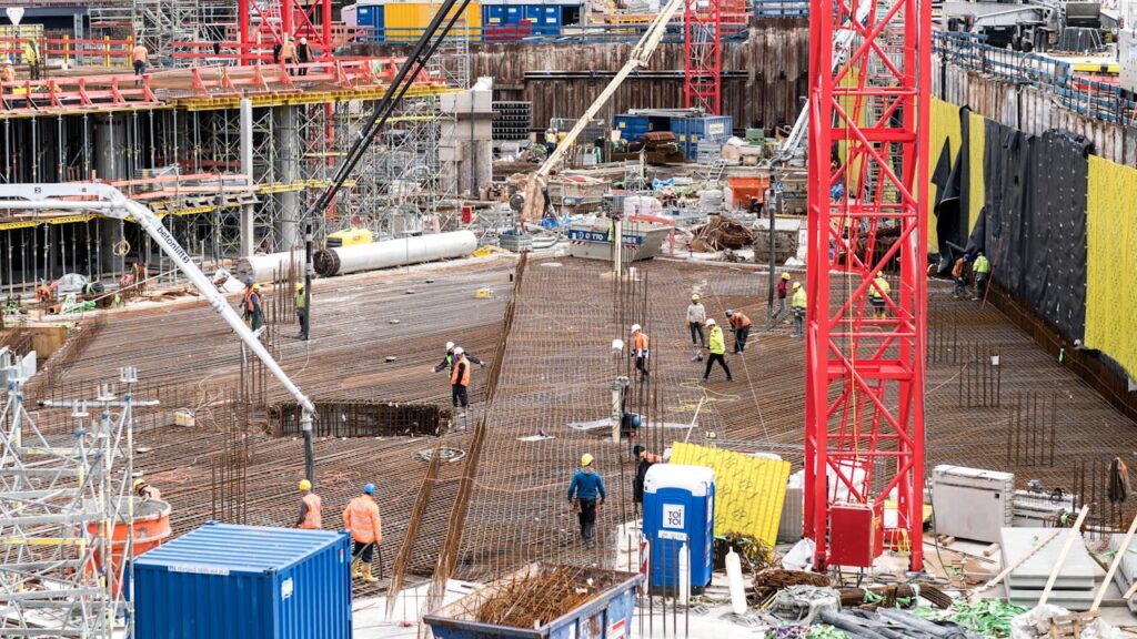 Workers Laying Out Concrete Reinforcements at the Construction Site